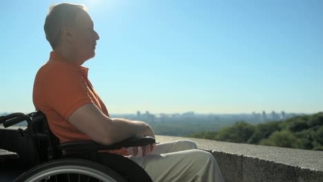 Pleasant-concentrated-wheelchaired-man-enjoying-the-city-from-observation-point