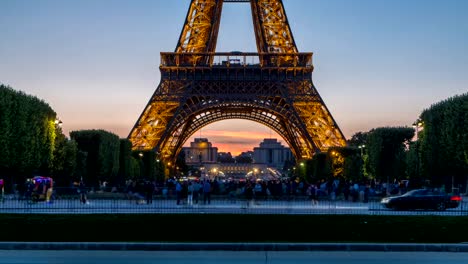 Día-de-la-Torre-Eiffel-para-timelapse-noche-y-personas-sentadas-en-la-hierba-por-la-noche-en-París,-Francia