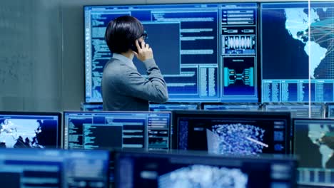 In-the-System-Control-Room-IT-Administrator-Talks-on-the-Phone-with-His-Superiors.-He's-in-a-High-Tech-Facility-That-Works-on-the-Surveillance,-Neural-Networks,-Data-Mining,-AI-Projects.