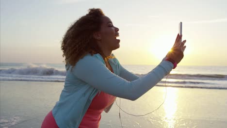 Étnica-mujer-videoing-en-teléfono-inteligente-por-océano