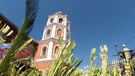 Menschen-Welle-Kokospalme-verlässt-am-Palmsonntag-Feier.-Das-fest-erinnert-an-den-triumphalen-Einzug-Jesu-in-Jerusalem.-Kirchturm-Hintergrund