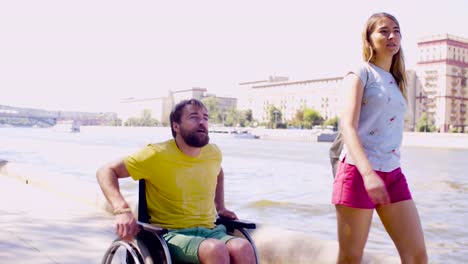 Young-disable-man-on-a-walk-near-the-river-with-his-wife