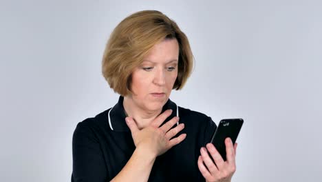 Alte-Frau-unter-Schock-während-mittels-Smartphone