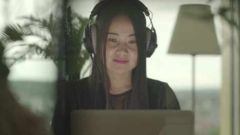 Young-woman-sitting-at-home-working-with-computer-and-chair-dancing