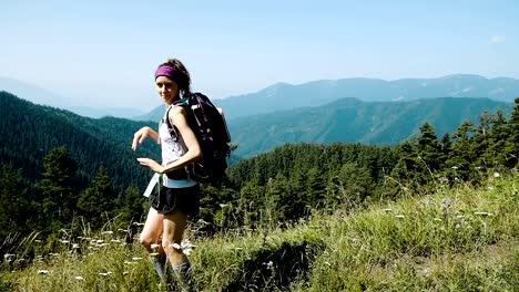 Frau-Tourist-mit-Rucksack-lustig-tanzen-und-springen-mit-Glück-auf-dem-Hintergrund-einer-wunderschönen-Berglandschaft-während-der-Kampagne-hebt-seine-Hände-oben,-Slow-motion