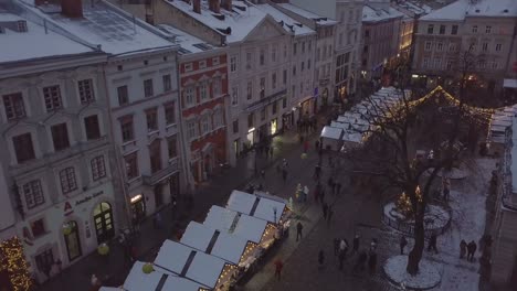 Lviv,-Ucrania---25-de-diciembre-de-2018.-Tiro-de-Arial.-Invierno.-Calle-plaza-Rynok.-Feria-de-Navidad.-Ayuntamiento-de-Lvov,-Consejo-de-la-ciudad.-Personas-están-caminando-en-el-centro-de-la-ciudad.-Adornos-navideños-y-luces.-Noche