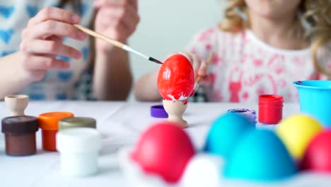 La-niña-y-la-madre-para-colorear-huevos-para-Pascua