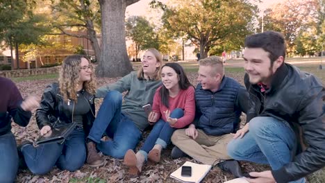 Close-group-of-college-friends-hanging-outside-with-their-smart-phones