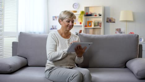 Aplicación-de-tableta-de-desplazamiento-femenino-retirado-relajante-en-casa,-compras-en-línea