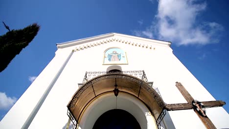 Una-antigua-iglesia-pequeña,-y-junto-a-la-alta-TUI-que-aleteo-del-viento