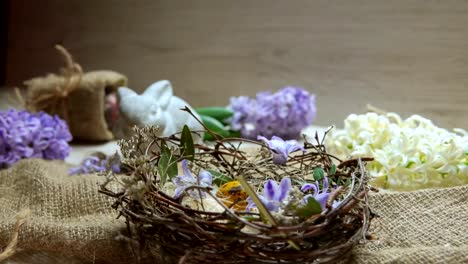 Child's-hand-puts-colored-egg-in-in-the-Easter-nest