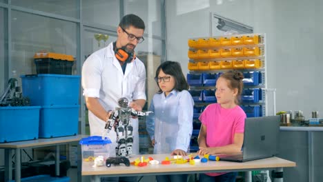 Lehrerin-zeigt-Kinder-Roboter-in-Technik-Wissenschaftsklasse