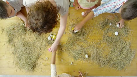 Top-Blick-auf-Kinder-und-Lehrer-bei-der-Vorbereitung-von-Osterdekorationen-in-der-Kunstklasse