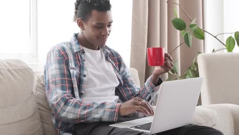 Man-having-coffee-and-using-laptop-at-home