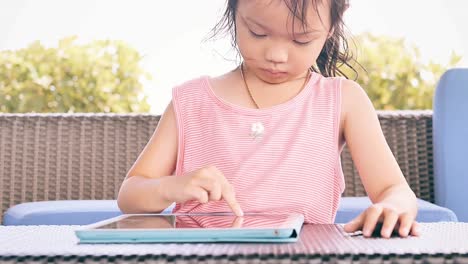 Happy-Asian-girl-using-smart-tablet-on-table,-lifestyle-concept.