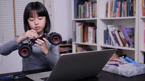 Niña-tratando-de-hacer-robot-solo-en-la-escuela.-Chica-que-tiene-talento-y-ella-trata-de-arreglar-el-robot-por-sí-misma.-Concepto-de-Tecnología-y-Educación.