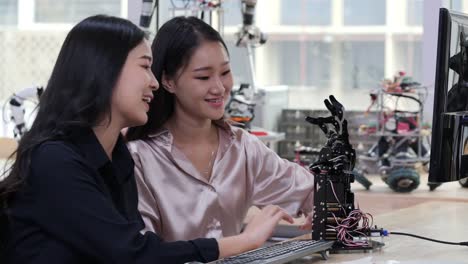 Asian-young-electronics-engineer-try-to-fix-robot-at-lab.-Technology-and-innovation-concept.