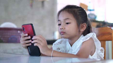 Asia-girl-playing-game-online-on-mobile-phone