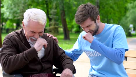 Male-volunteer-and-elderly-disabled-man-laughing-in-park,-lonely-pensioners-care