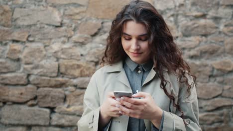 Zeitlupe-von-hübschen-Mädchen-mit-Smartphone-in-Der-Straße-berühren-Bildschirm-lächelnd