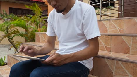 Man-holding-using-tablet-play-game-online-at-home