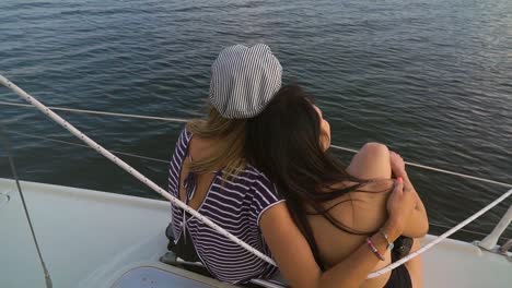 back-view-of-young-lesbian-family-enjoying-sunset-on-sailboat