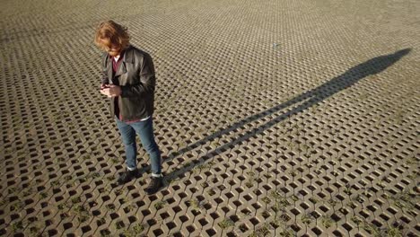 Young-Stylish-Ginger-Man-with-Smartphone-Outdoors