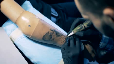 Black-ink-tattoo-is-being-made-on-a-male-prosthetic-arm