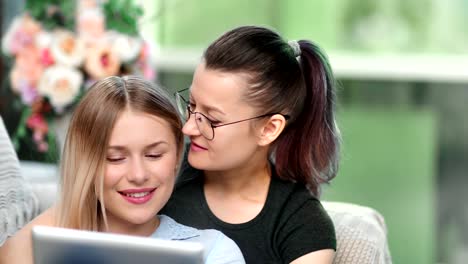 Tenderness-same-sex-couple-enjoying-watching-tablet-pc-entertainment-kissing-feeling-love-close-up