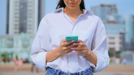 details-woman-holding-smartphone-walks-urban-city-background