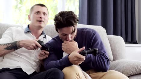 Pareja-gay-relajándose-en-el-sofá-con-el-perro-jugando-juegos.-Divirtiendo.