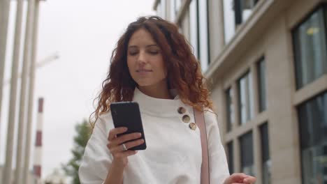 Schöne-junge-Frau-mit-Telefon-im-Freien