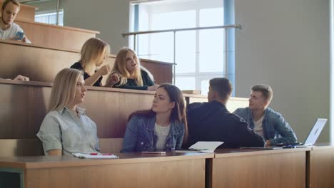 Un-gran-grupo-de-estudiantes-durante-el-descanso-se-comunican-entre-sí-en-el-salón-de-clases.-Los-estudiantes-de-Modern-College-se-comunican