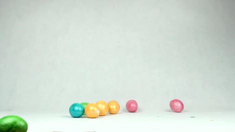 Multi-colored-Easter-eggs-fall-on-the-table,-the-skin-breaks,-the-white-background-is-the-concept-of-the-end-of-the-holidays,-slow-motion,-copy-space,-background