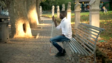 blindness,-independence.Blind-African-man-sitting-on-bench-in-the-park