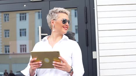 adult-Business-woman-with-tablet-pc-with-office-district-on-background