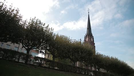 Old-Church-in-Gothic-style.-With-pointed-roof-and-clock.-In-foreground-is-trees