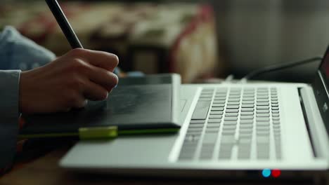 closeup-womans-hands-with-pen-tablet-and-laptop.-woman-freelancer-retoucher-working-at-home