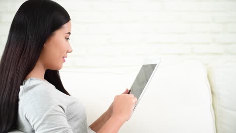 Asian-woman-using-tablet-computer-shopping-online-website-on-smartphone-with-smiling-face.-Happiness-asian-woman-holding-cellphone-checking-mail-from-online-shopping-website-read-article-Blog-vlog-social-media