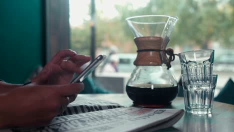 Close-up-of-female-hands-print-sms-on-your-mobile-phone-in-a-cafe