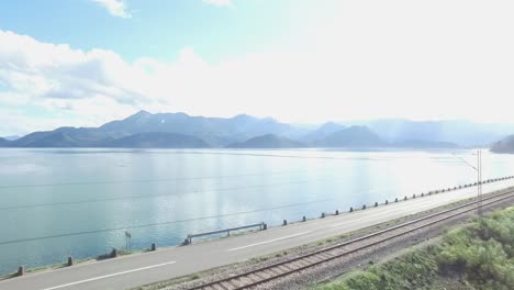 Aerial-viev-on-landscape-of-sea-shore-and-blue-sky-and-mountains-background.-Footage.-Aerial-view-of-blue-sky,-sea-and-mountains