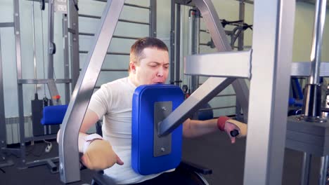 Man-in-wheelchair-overcomes-himself-in-doing-exercises-in-gym.