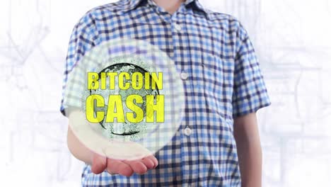 Young-man-shows-a-hologram-of-the-planet-Earth-and-text-Bitcoin-cash