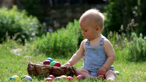 Niedlichen-Kind,-spielt-mit-kleinen-Häschen-und-Ostern-Eier-in-einen-blühenden-Garten,-Frühling.-Junge-mit-Kaninchen-spielen,-Ei-Jagd-für-Urlaub