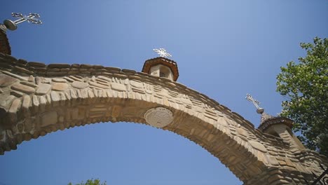 Iglesia-ortodoxa,-la-puerta-de-entrada-al-territorio-de-la-iglesia-ortodoxa,-el-arco-y-soleada-mañana,-árboles-verdes