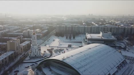 Vista-aérea-de-la-iglesia-en-Rusia.-Vista-aérea-de-un-paisaje-urbano-de-una-ciudad-con-un-río-de-travesía-en-invierno.-Stock.-Blanco-techos-cubiertos-de-nieve-y-nieve-en-toda-la-ciudad