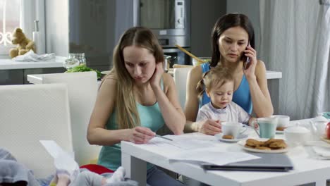 Weibliche-Ehepaar-mit-Kindern,-die-von-zu-Hause-aus-arbeiten