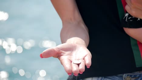 Woman-hand-holding-golden-Bitcoin-on-seashore-background.-virtual-currency-as-a-symbol-of-freedom.