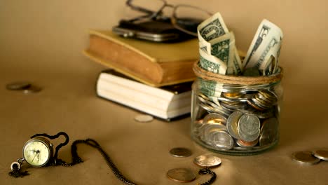 Books-with-glass-penny-jar-filled-with-coins-and-banknotes.-Tuition-or-education-financing-concept.-Scholarship-money.