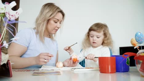 Mutter-und-ihre-kleine-Tochter-bemalen-von-Ostereiern